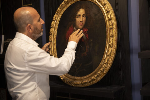Un commissaire-priseur expertise un tableau ancien à Arles