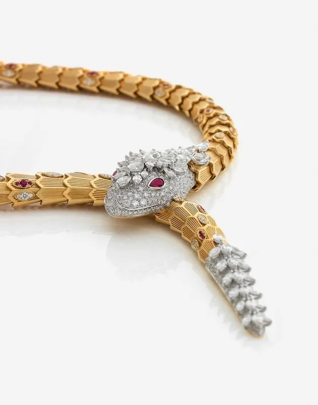BULGARI - Collier "Serpenti" - En or jaune et gris 18k, articulé, stylisant un serpent serti de rubis et de diamants taillés en brillant,
