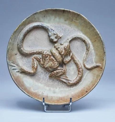 Alfred Jean HALLOU (1875-1939) ASSIETTE ronde en grès émaillé brun à décor en bas-relief d'un serpent dévorant une grenouille. Signée et datée 1900 sous la base. Adjugé à 5 000 €