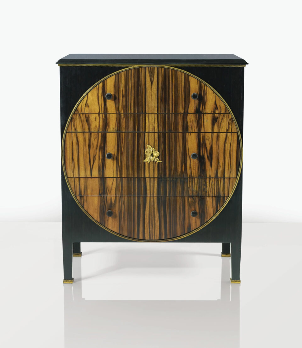 Paul IRIBE (1883-1935) Commode à corps quadrangulaire en placage d'ébène et de bois exotique veiné à plateau rectangulaire en marbre noir souligné d'un jonc perlé en bronze doré. Adjugé à 170 000 €