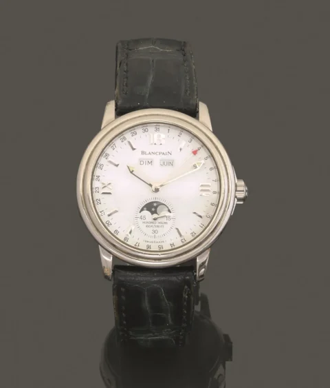 BLANCPAIN. LEMAN. RÉF. 2763. ANNÉES 2000. Montre bracelet en acier sur cuir avec triple quantième et phases de lune. Boîtier rond à gradins, couronnée t fond plein vissés, quatre correcteurs rapides sur la carrure. Cadran blanc, index appliqués, deux guichets